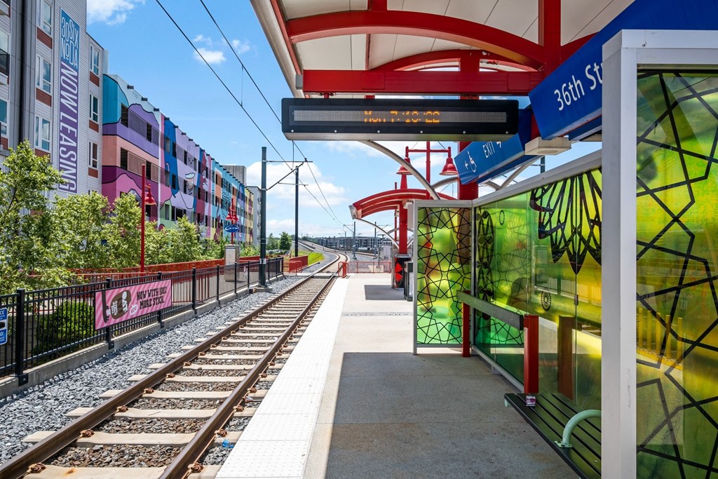 a train station with train tracks and buildings on the side of it at The Collection Charlotte in Charlotte, NC, 28205
