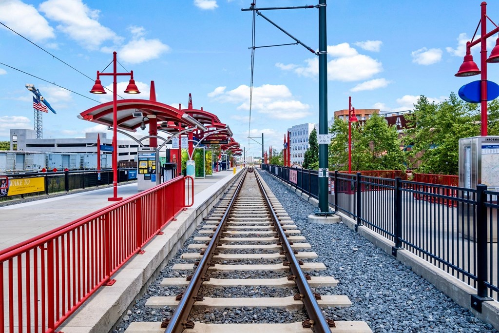 a train station with train tracks and a red and black fence at The Collection Charlotte in Charlotte, NC, 28205