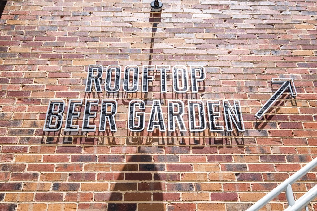 a brick wall with a sign on it that says root top beer garden at The Collection Charlotte in Charlotte, NC, 28205