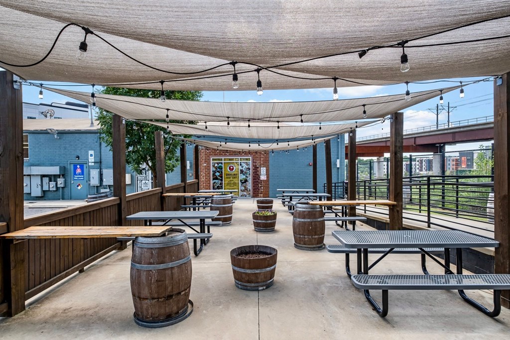 a covered patio with tables and barrels at The Collection Charlotte in Charlotte, NC, 28205