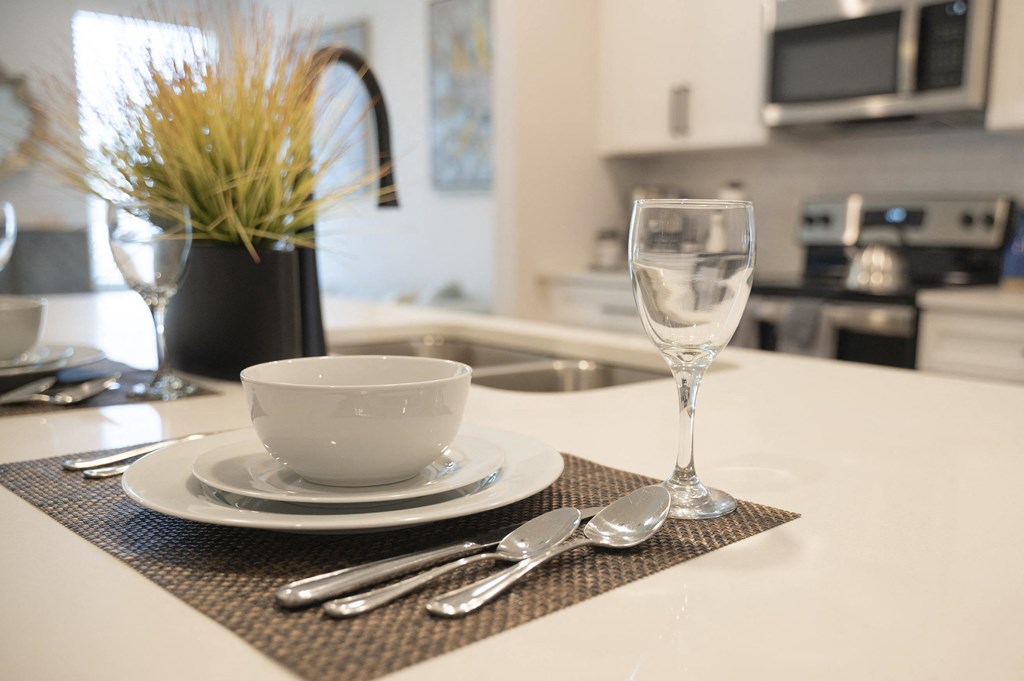 a place setting on a kitchen counter with a sink and microwave in the background at Landon Green Artisan Cottages Apartments, North Carolina, 28601