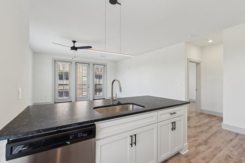 A kitchen with black countertops and white cabinets.