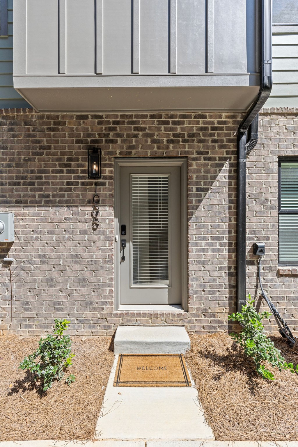 a front door of a brick house with a sidewalk in front of it at The Collection Charlotte in Charlotte, NC, 28205