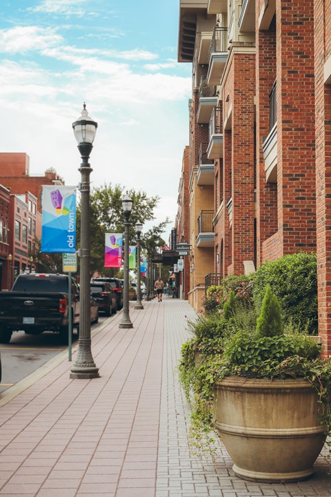 a city street with brick buildings and street lamps