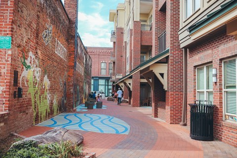 a city street with brick buildings and a blue rug on the sidewalk