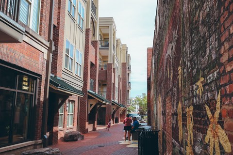 people walking down a city street next to brick buildings