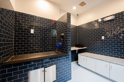 a bathroom with black tiles and white cabinets and a sink