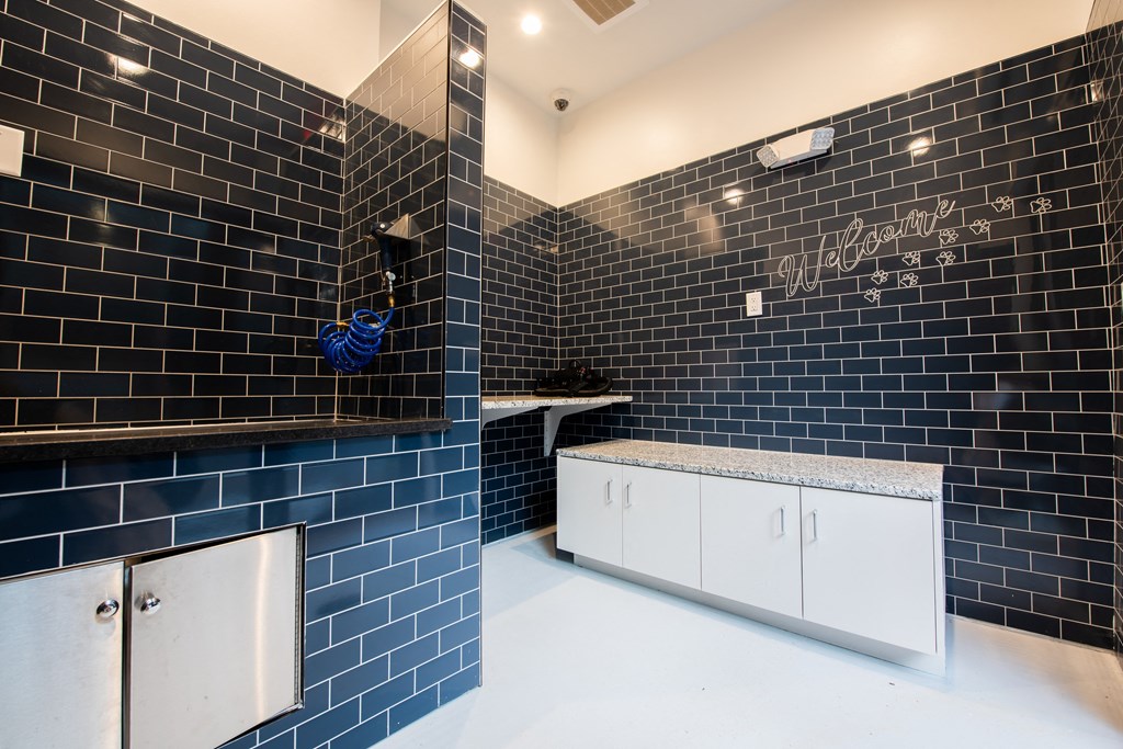a bathroom with black tiles and a sink and a mirror