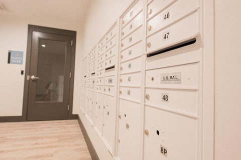 a row of white lockers in a hallway with a door