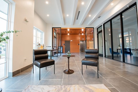 a lobby with chairs and a table in front of a door