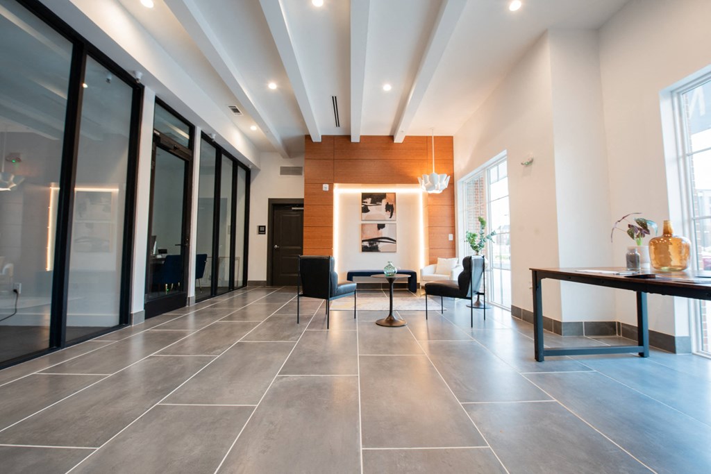 a living room with a table and chairs and a large tile floor