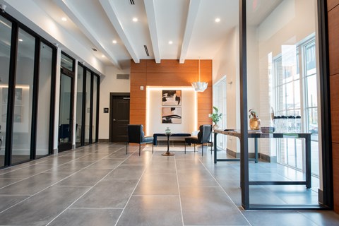 a large lobby with a table and chairs and glass doors
