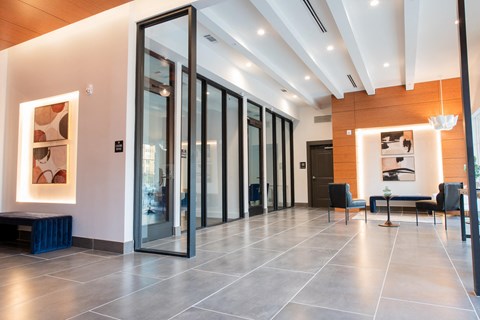 a lobby with glass doors and a table with chairs