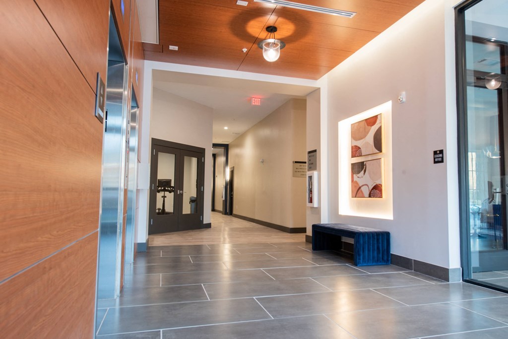 a long hallway with a ceiling fan and glass doors