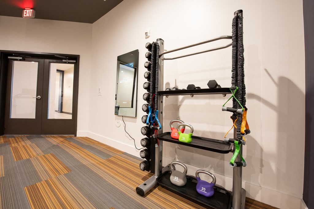 a fitness room with weights and a treadmill