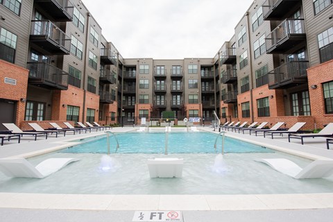 a swimming pool in front of an apartment building