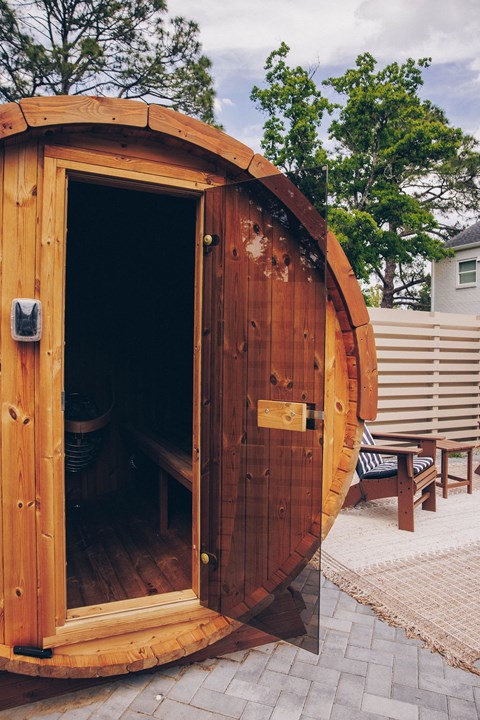 A wooden pod with a door open to a bench inside.