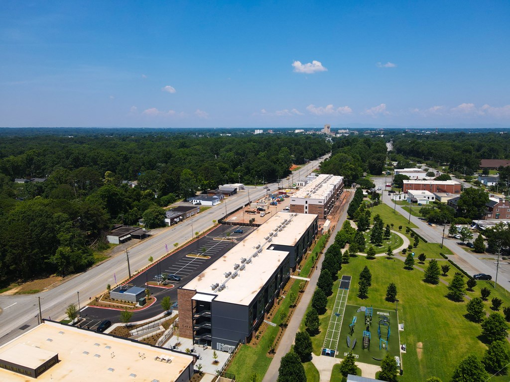A view of a school with a basketball court and a green field.