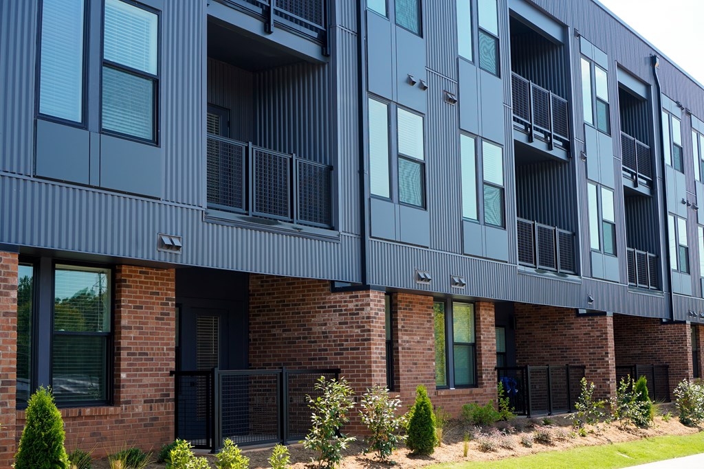 A modern building with a black facade and balconies.