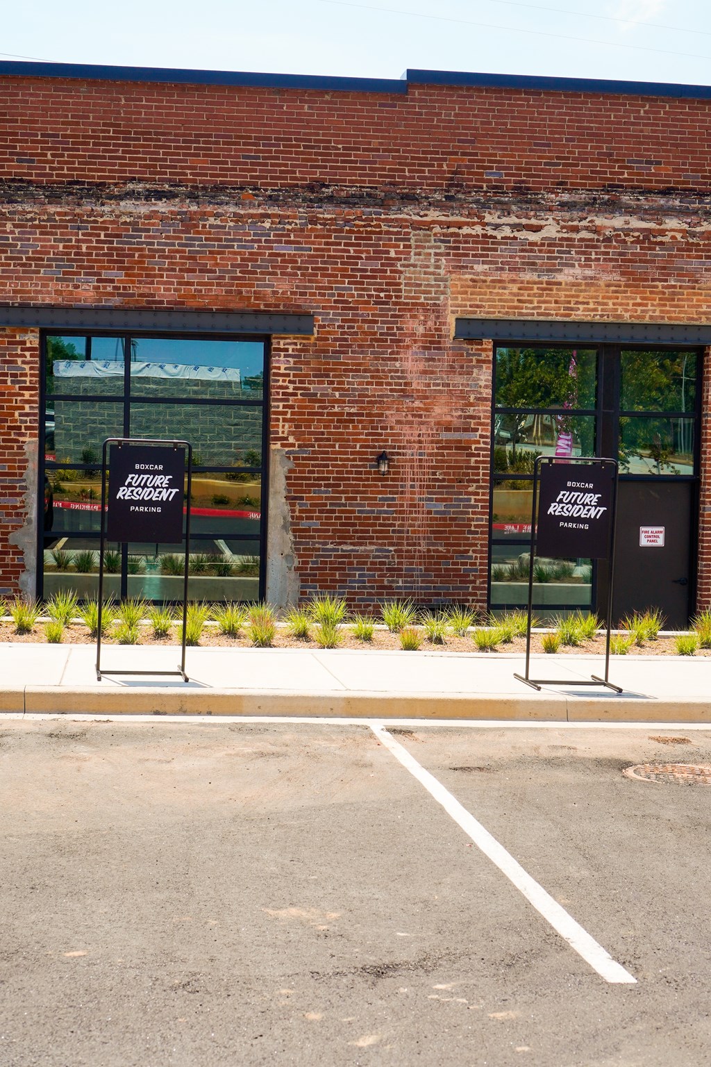 Two signs on a pole in front of a brick building that say "Future Resident".