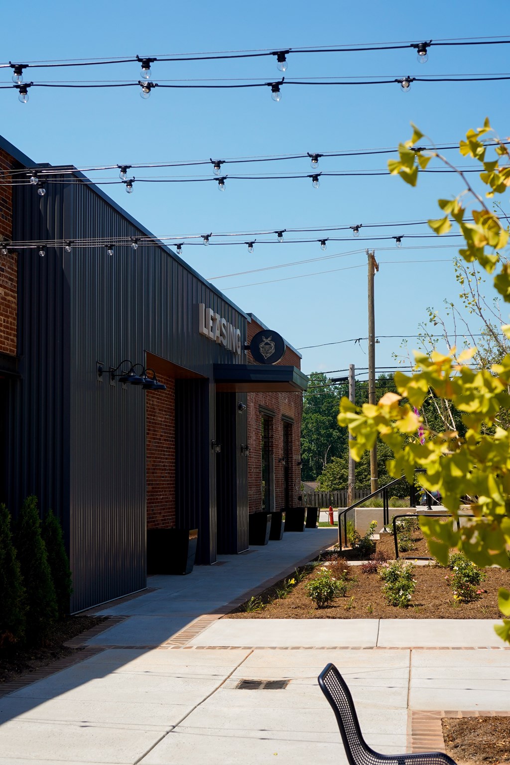A street view with a building on the left and a bench on the right.