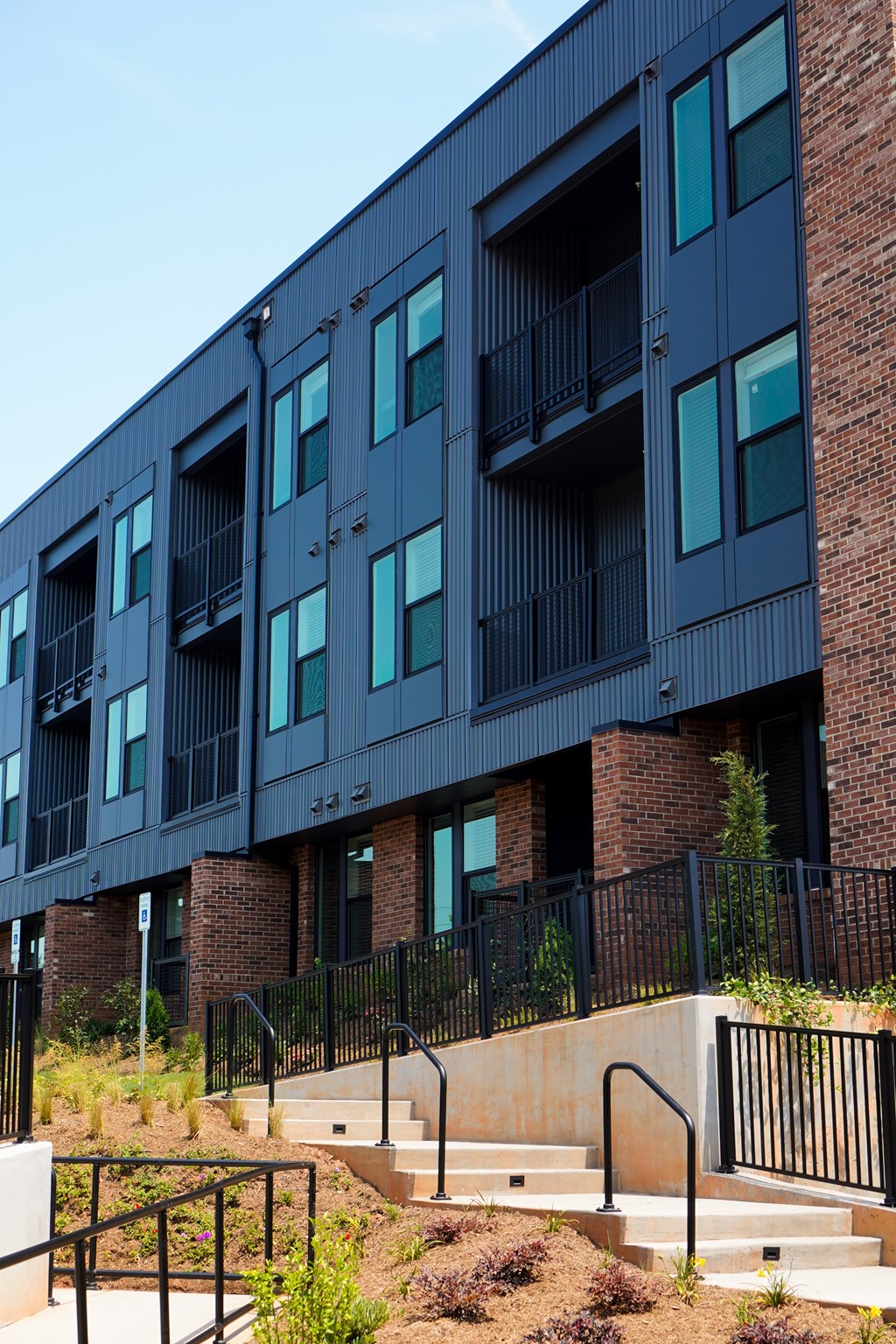 A modern building with black balconies and glass windows.