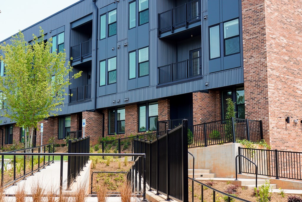 A black building with a tree in front of it.