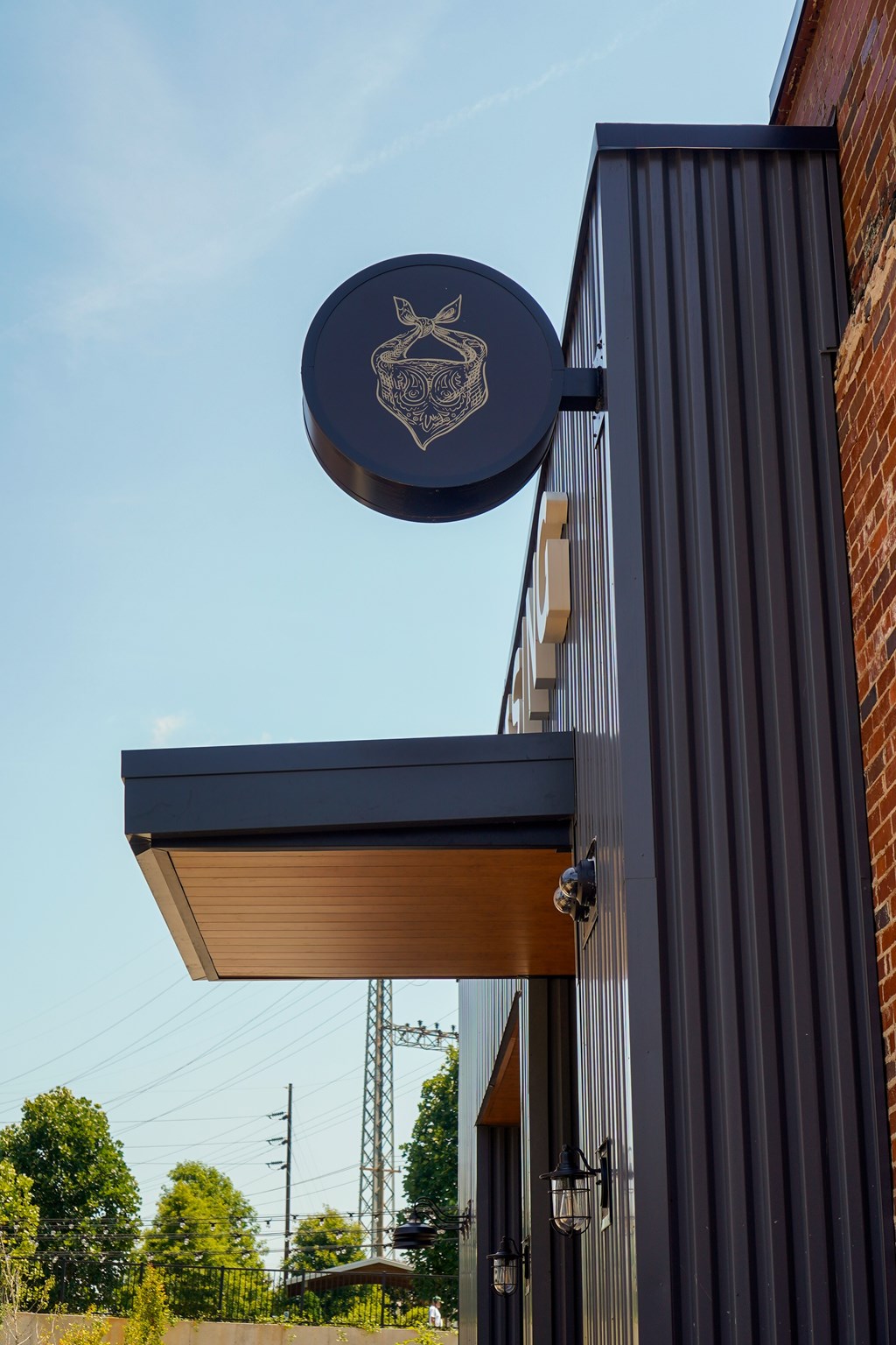 A blue sign with a white emblem hangs from a building.