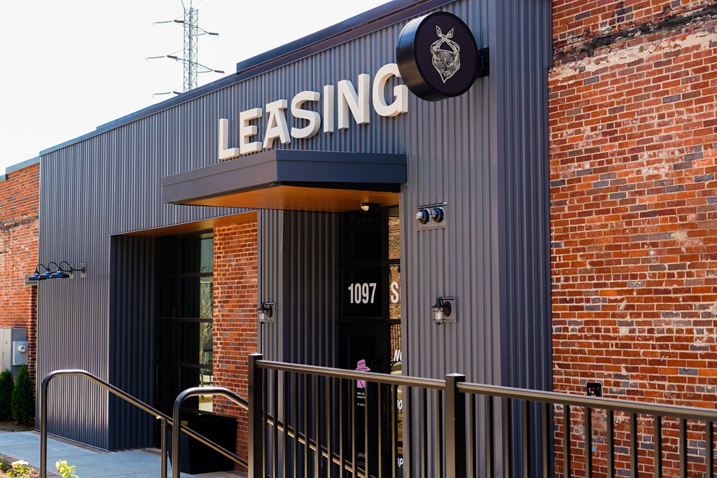 The front of a building with a sign that says "LEASING" on it.