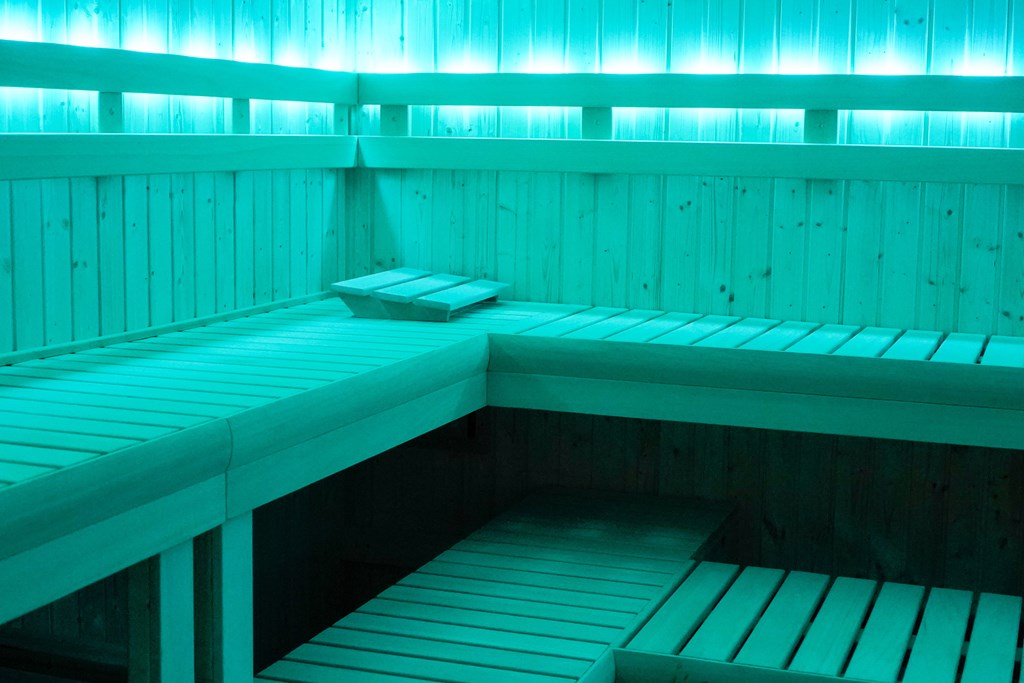 A wooden bench in a room with blue lighting.