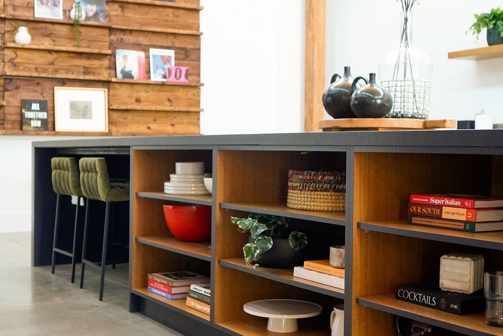 A shelf with a red bowl and a green vase on it.