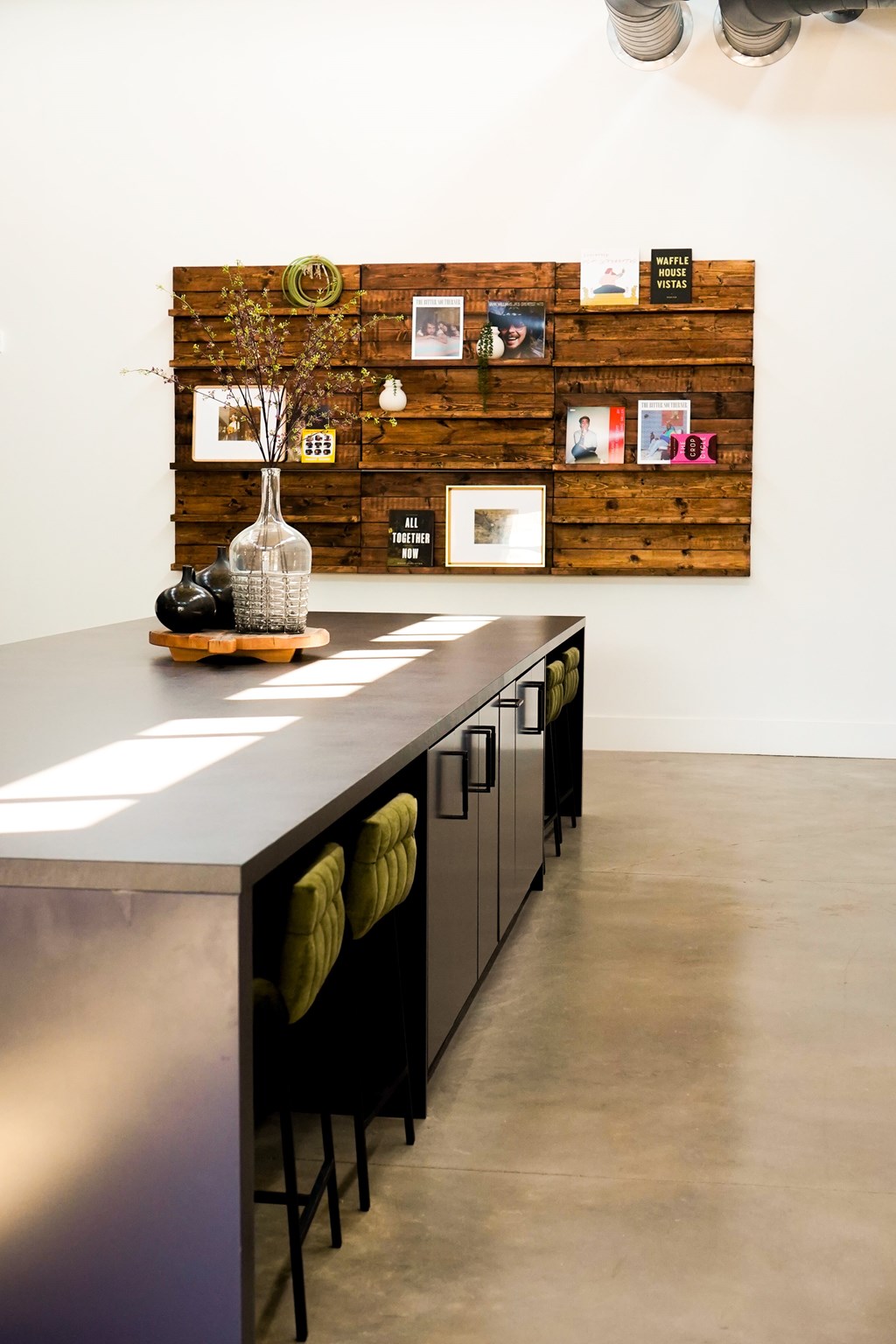 A long table with a vase on it and chairs around it.