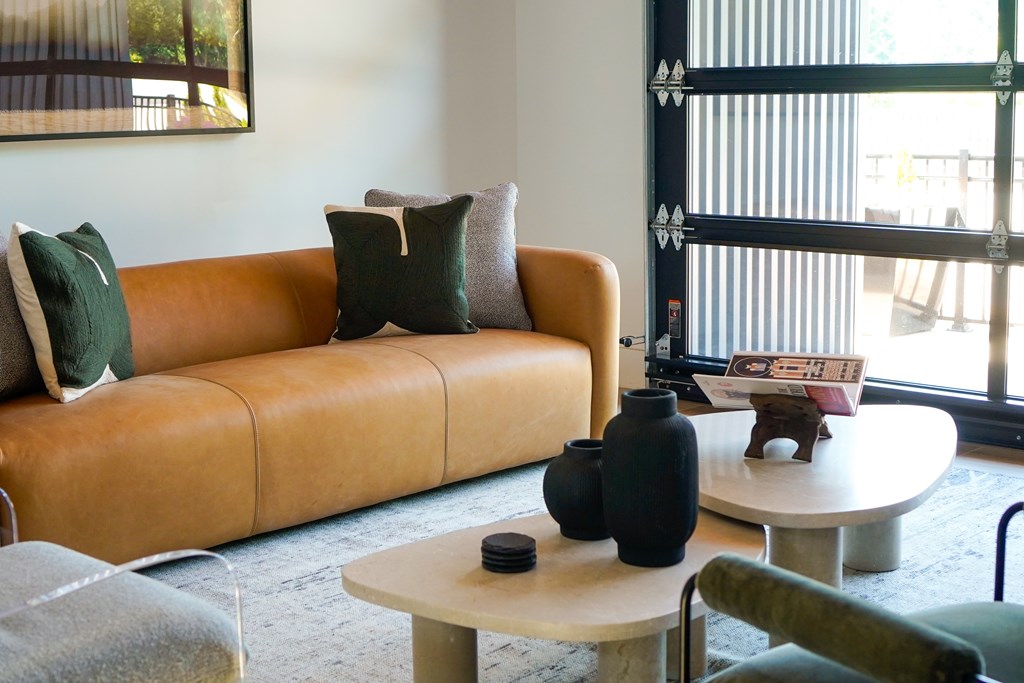 A living room with a tan couch, a white table, and a green chair.