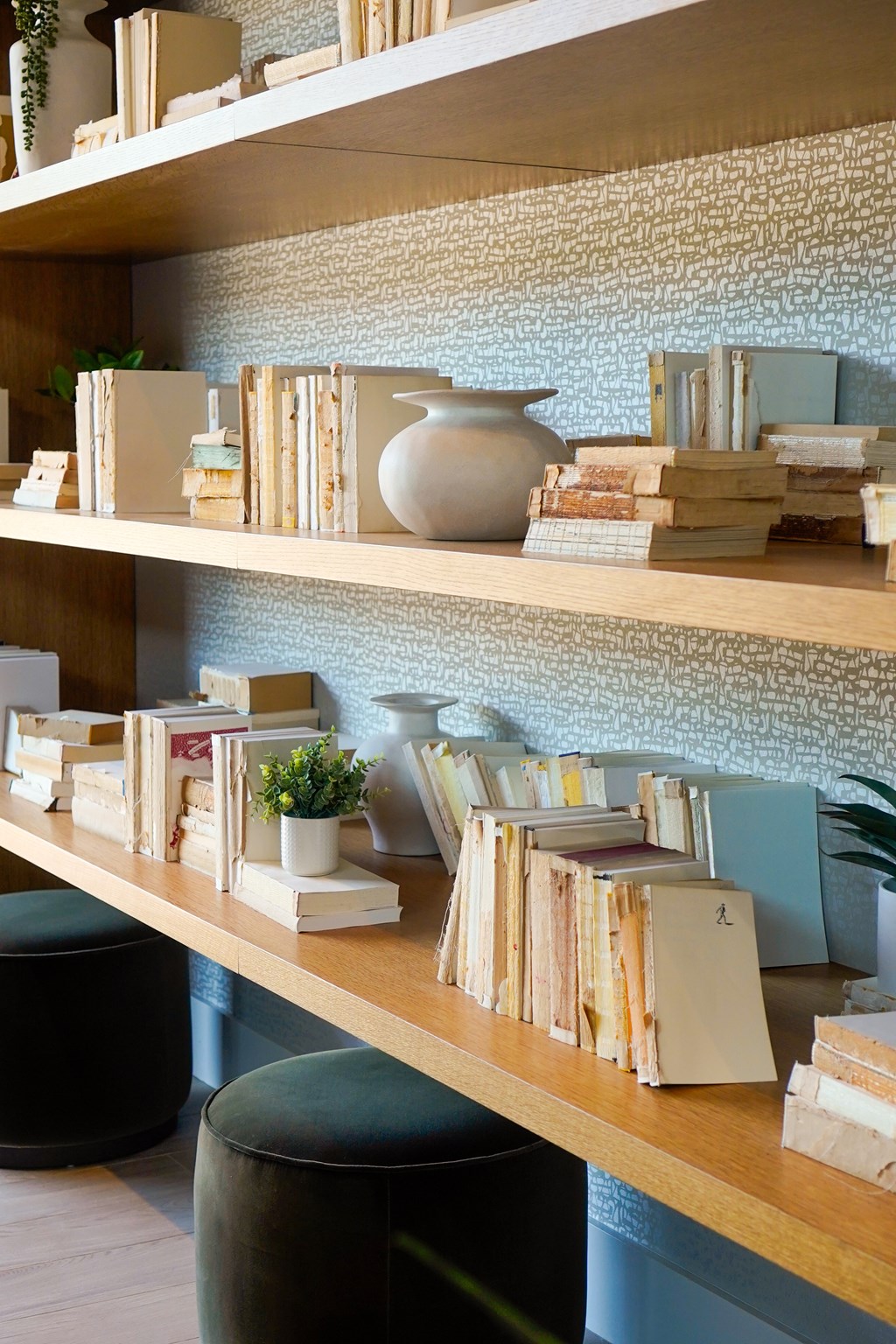 A shelf with books and a vase on it.