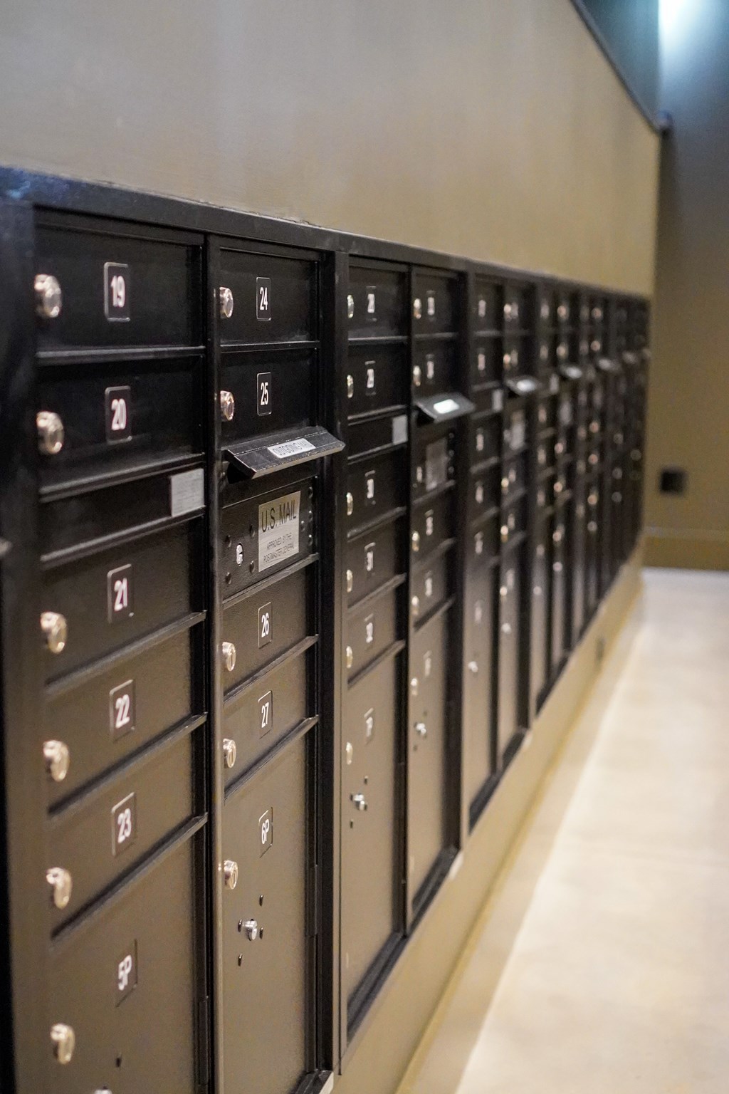 A row of black mailboxes with white lettering on them.