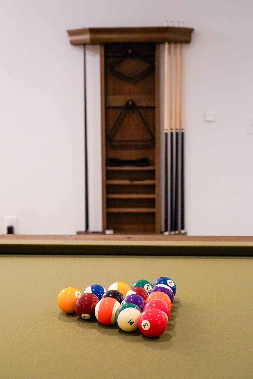 A pool table with a green cloth and a set of pool balls.