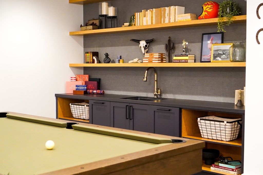 A pool table with a green felt cloth and a white ball in the middle.
