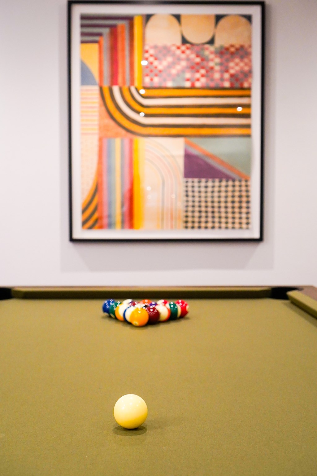 A pool table with a yellow ball and a few balls on the side.