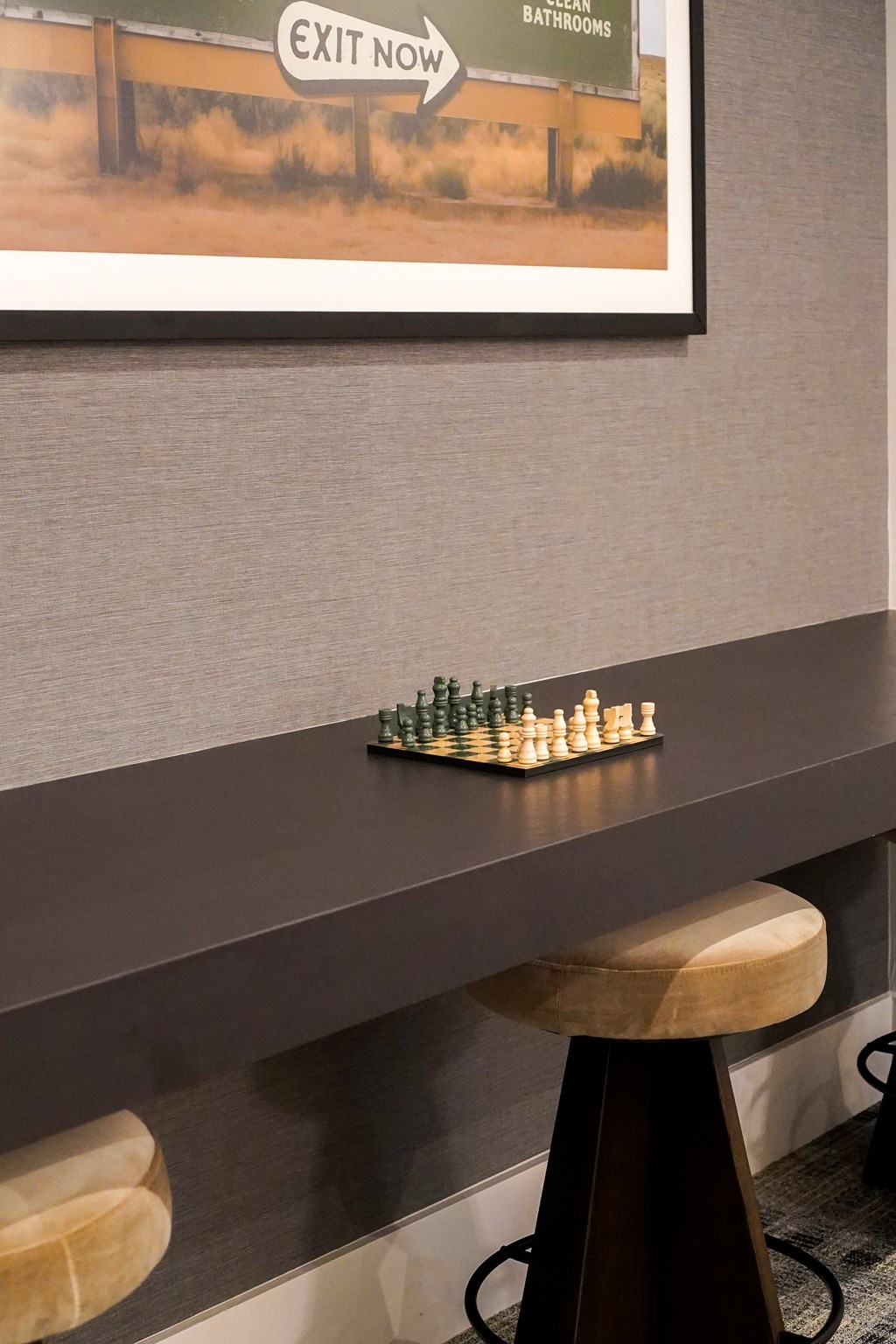 A chess set sits on a table in front of a poster.