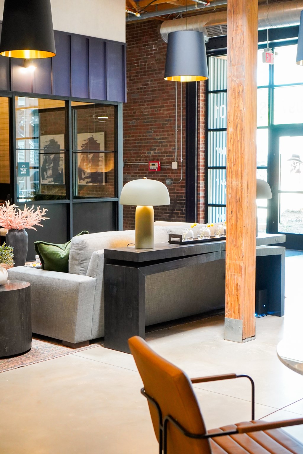 A modern living room with a grey sofa and a wooden floor.