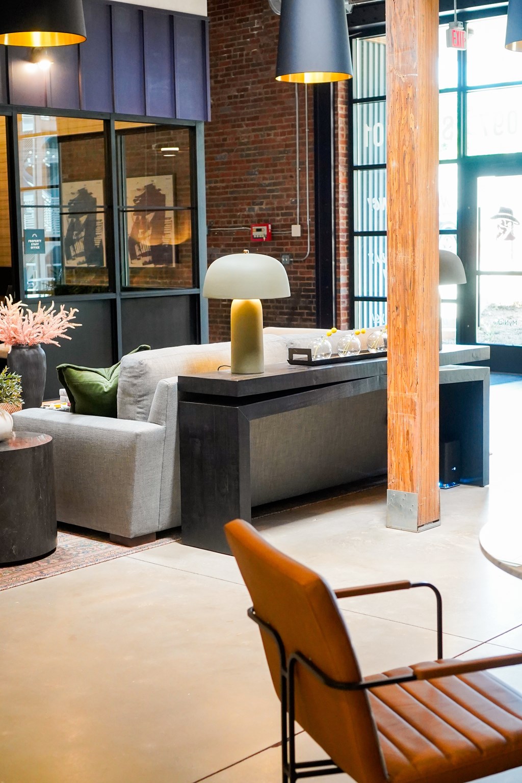 A modern living room with a grey sofa and a wooden floor.