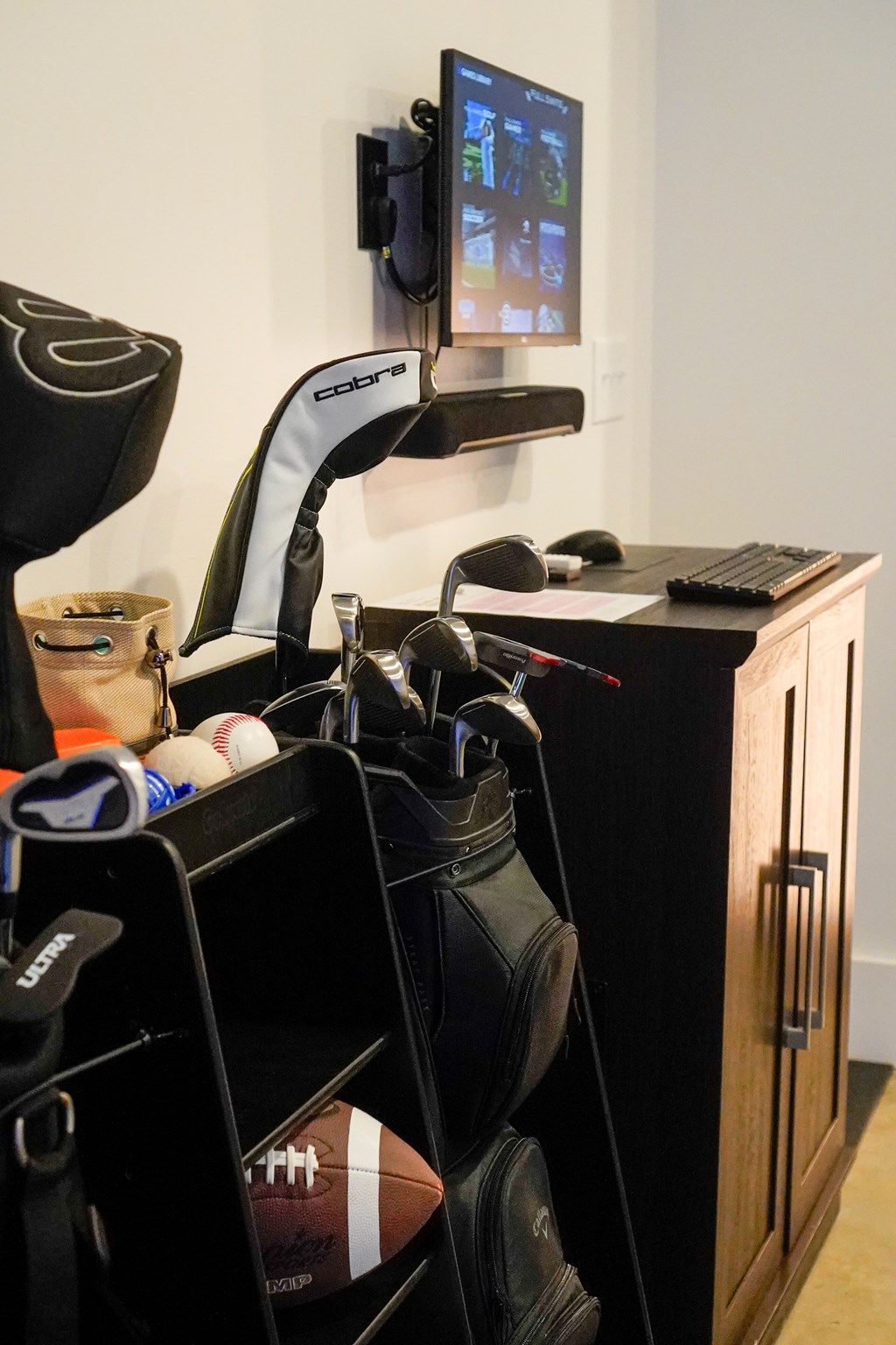 A room with a TV, a gaming chair, and a desk with a keyboard and mouse.