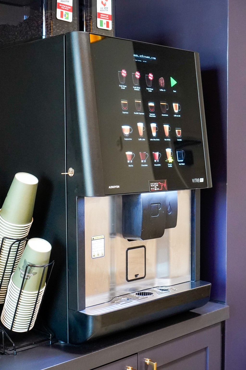 A black coffee machine with a digital display and buttons for different functions.