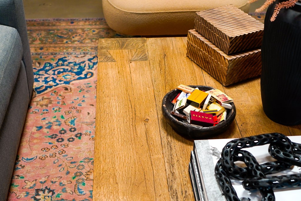 A wooden table with a hat and a chain on it.