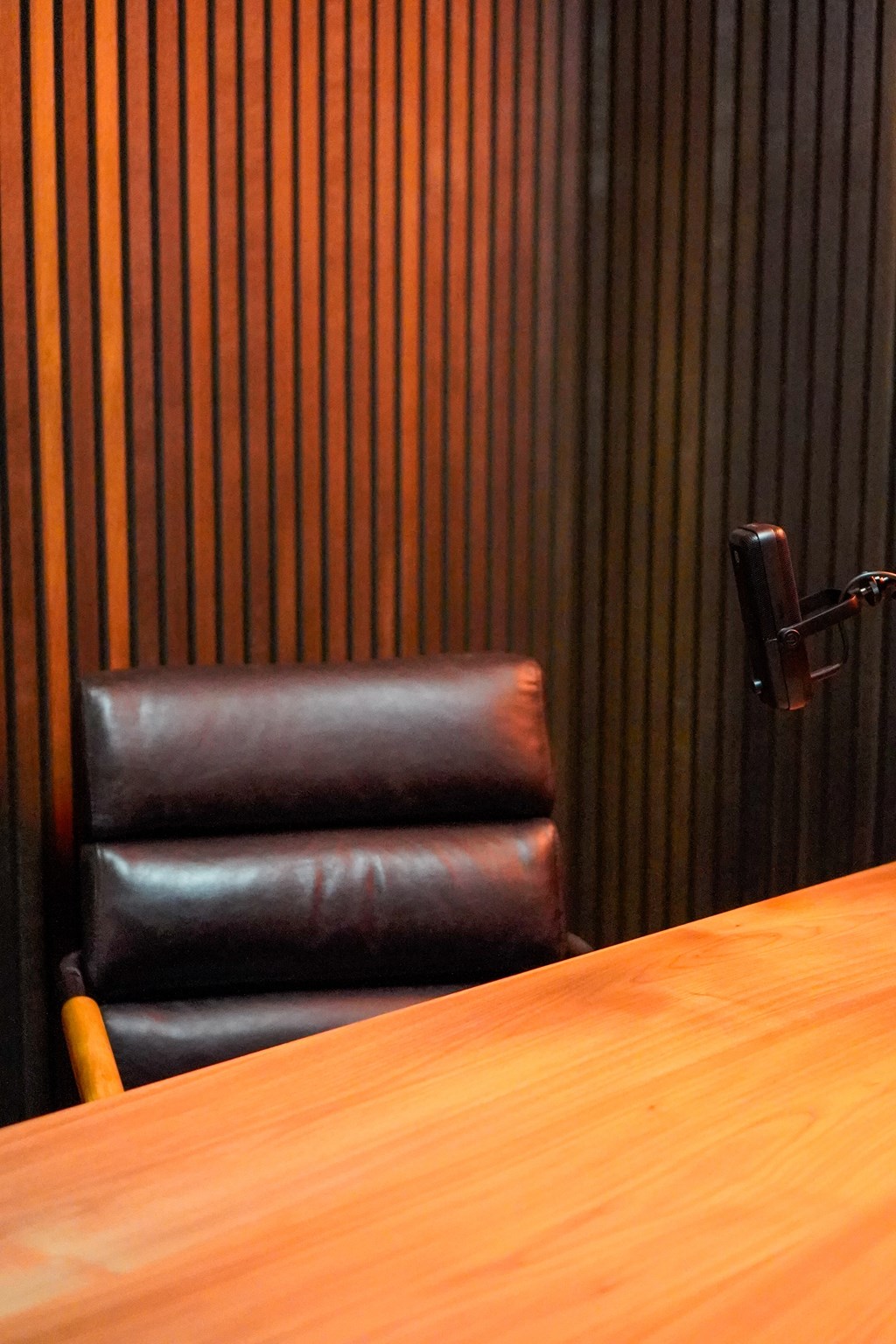 A brown leather chair sits in front of a wooden table.