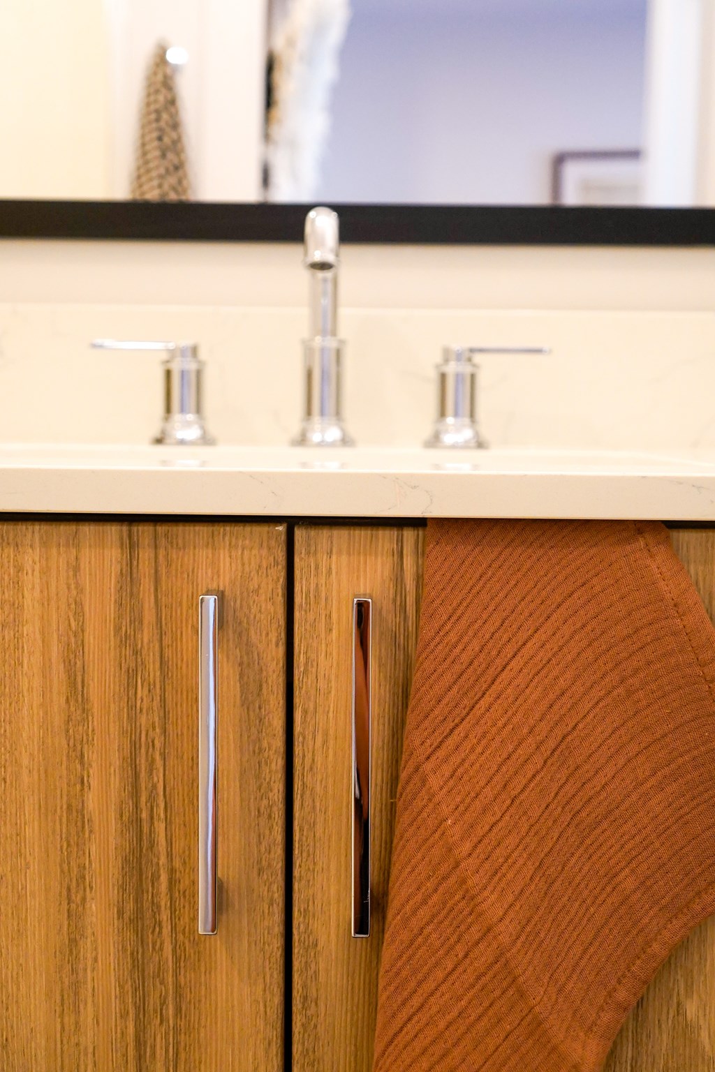 A brown towel hangs on a brown wooden cabinet.