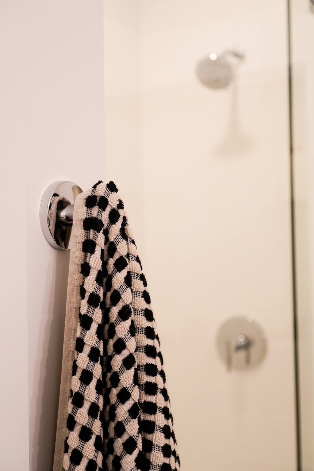 A towel with a black and white checkered pattern hangs on a door handle.