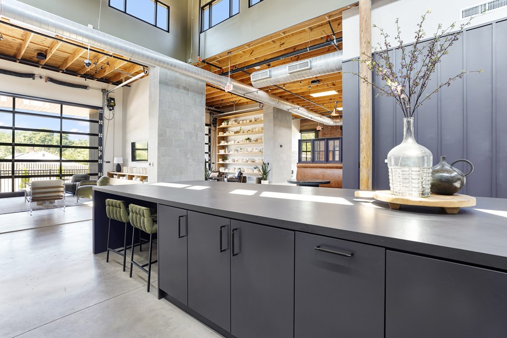 A kitchen with a long counter and bar stools.