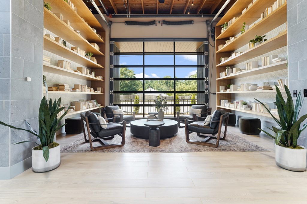 A modern living room with a large window and a glass door leading to a balcony.