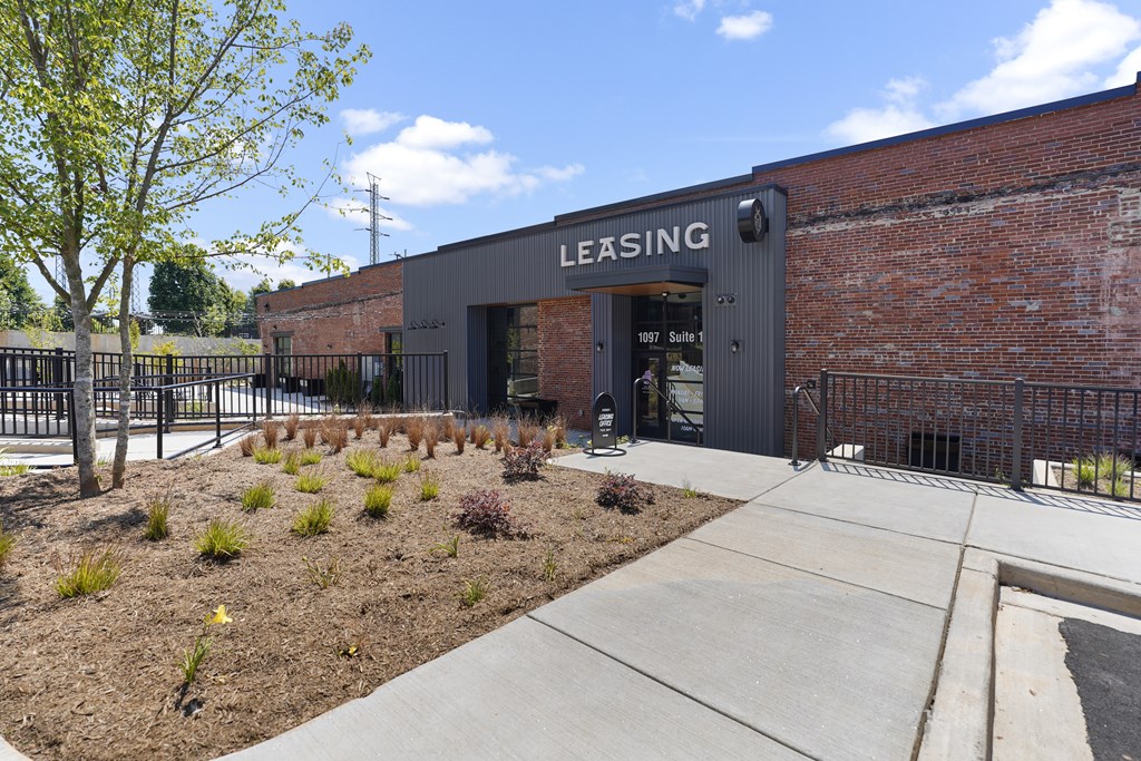 A brick building with a large sign that says "LEASING" on the front.